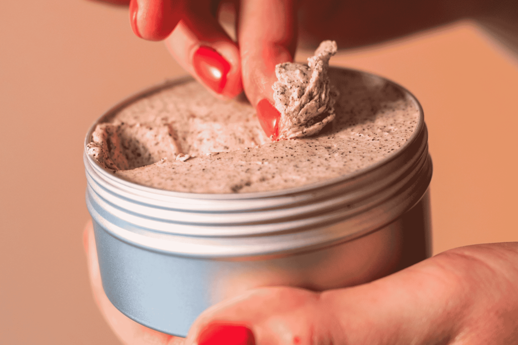 close up of the body scrub being taken out of the tin