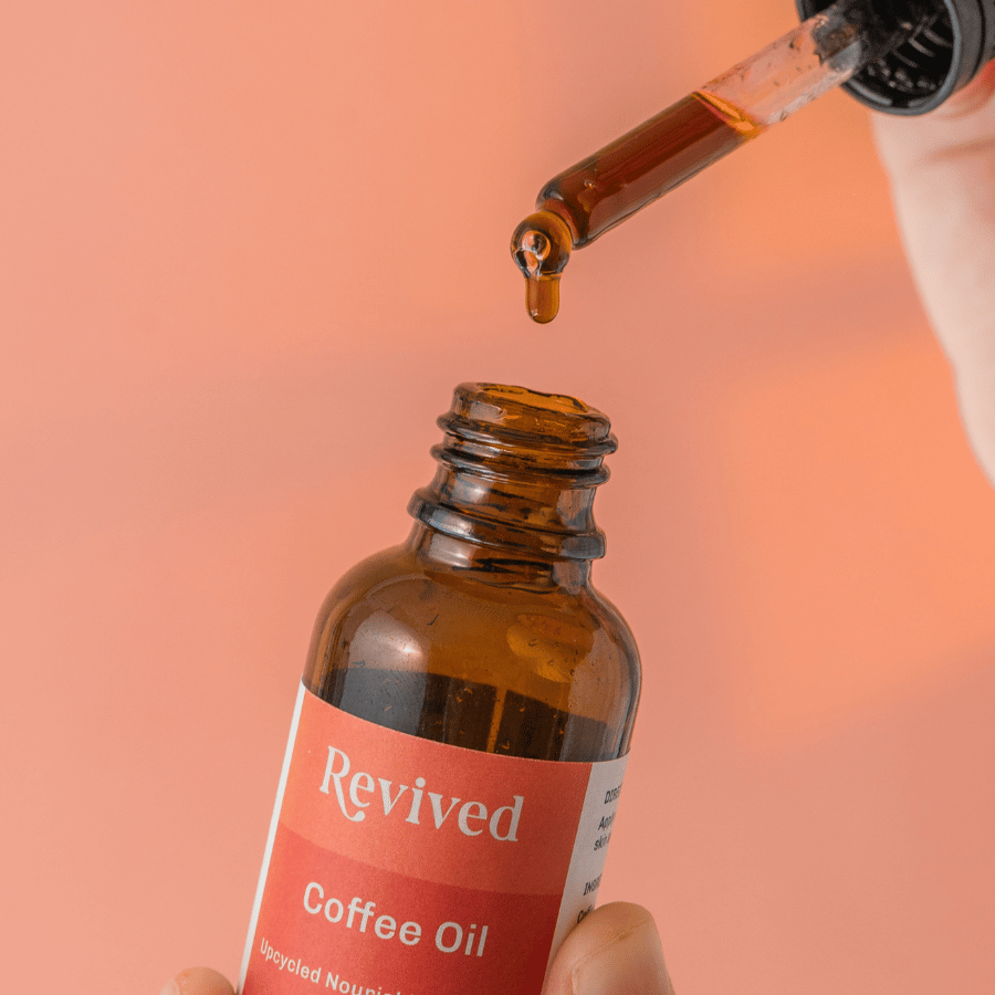 close up of the revived coffee oil one drop hanging from the dropper tip